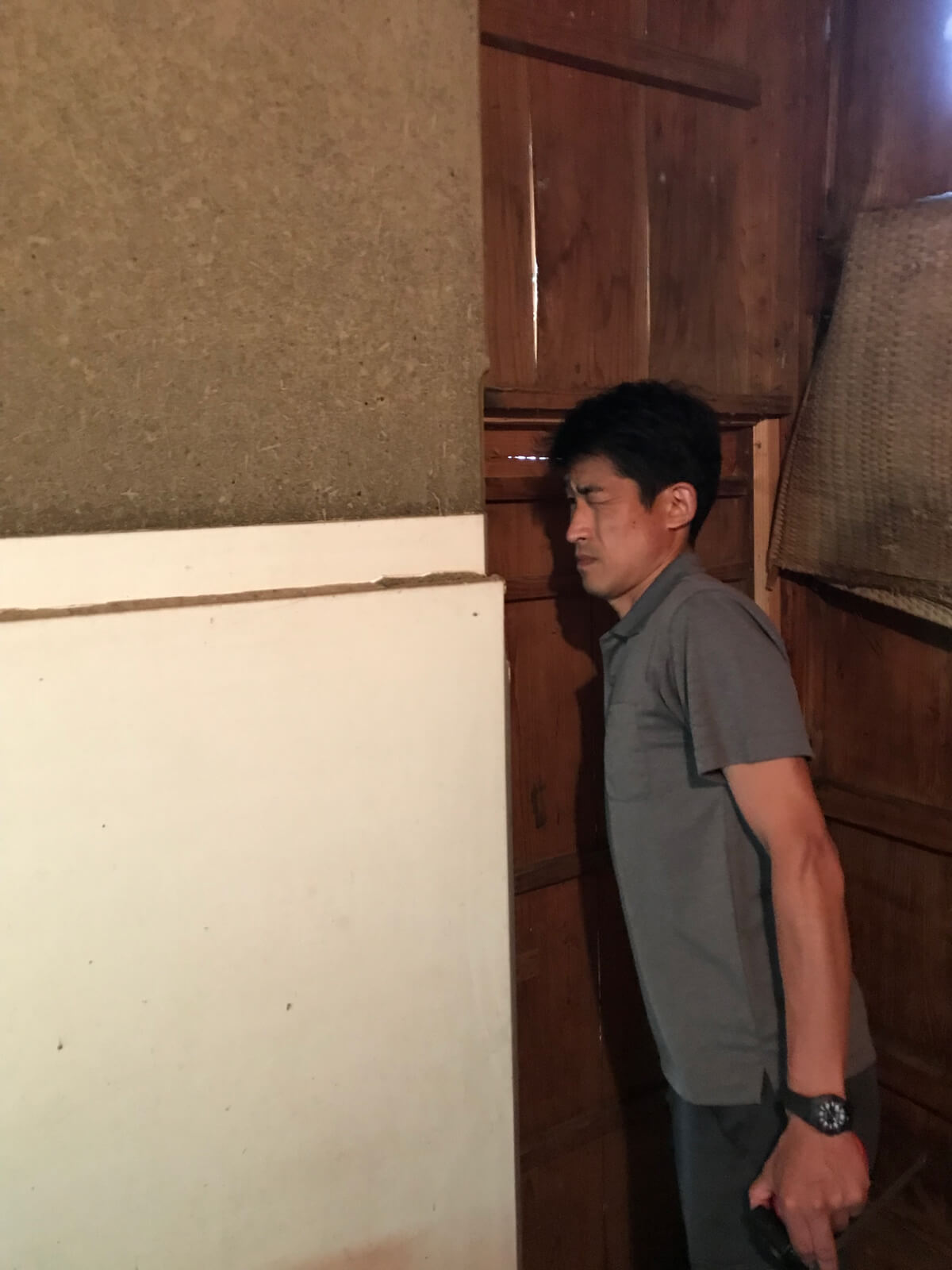 阿専の蔵、腰壁部分をチェックする左官屋山内さん