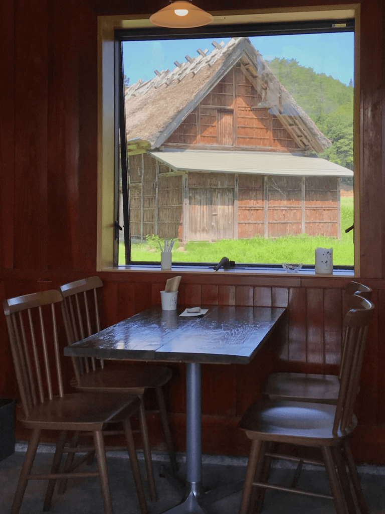 夏。阿専のカフェの窓から望む茅葺きの小屋